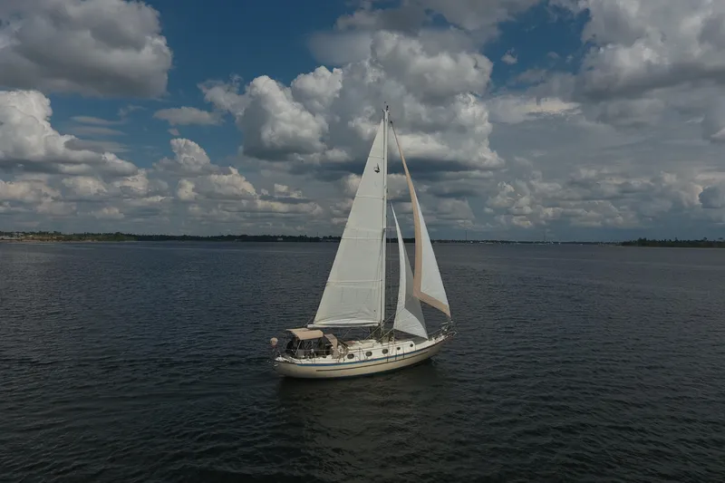 Slide: The Image of 1986 Pacific Seacraft Crealock 37 sailboat cruising on open water under cloudy skies. - 41