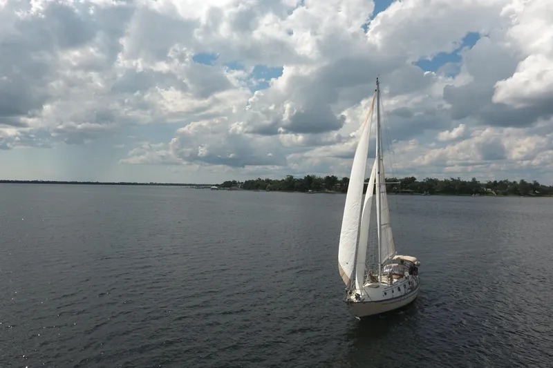 Slide: The Image of Sailboat Pacific Seacraft Crealock 37 (1986) cruising under cloudy skies on open water. - 46
