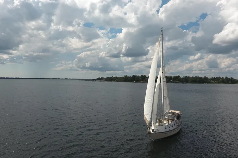 Slide: The Image of 1986 Pacific Seacraft Crealock 37 sailboat on open water under cloudy sky. - 47