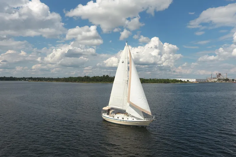 Slide: The Image of 1986 Pacific Seacraft Crealock 37 sailboat cruising on a calm lake under a partly cloudy sky. - 50