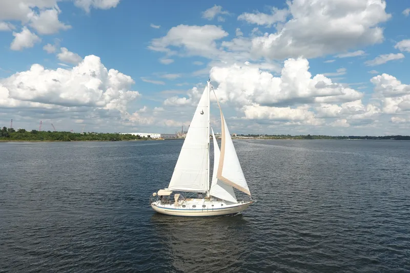 Slide: The Image of 1986 Pacific Seacraft Crealock 37 sailboat on open water under a partly cloudy sky. - 52