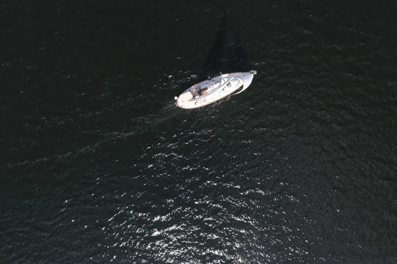 Slide: The Image of Aerial view of 1986 Pacific Seacraft Crealock 37 sailboat on dark water. - 53
