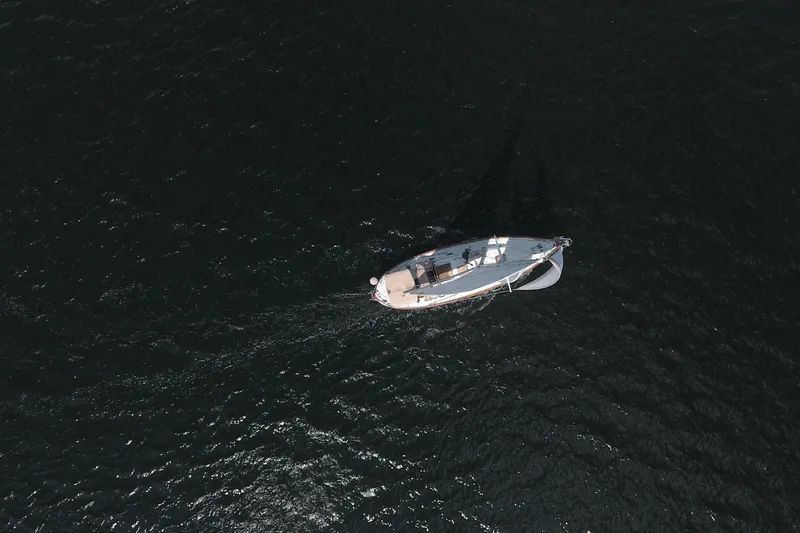 Slide: The Image of Aerial view of 1986 Pacific Seacraft Crealock 37 sailboat on dark water. - 54
