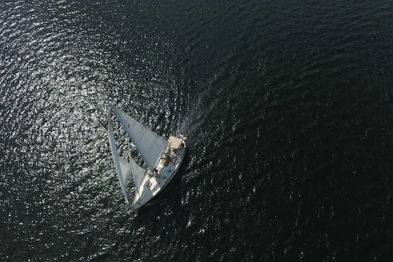 Slide: The Image of Aerial view of 1986 Pacific Seacraft Crealock 37 sailboat gliding on shimmering water. - 57