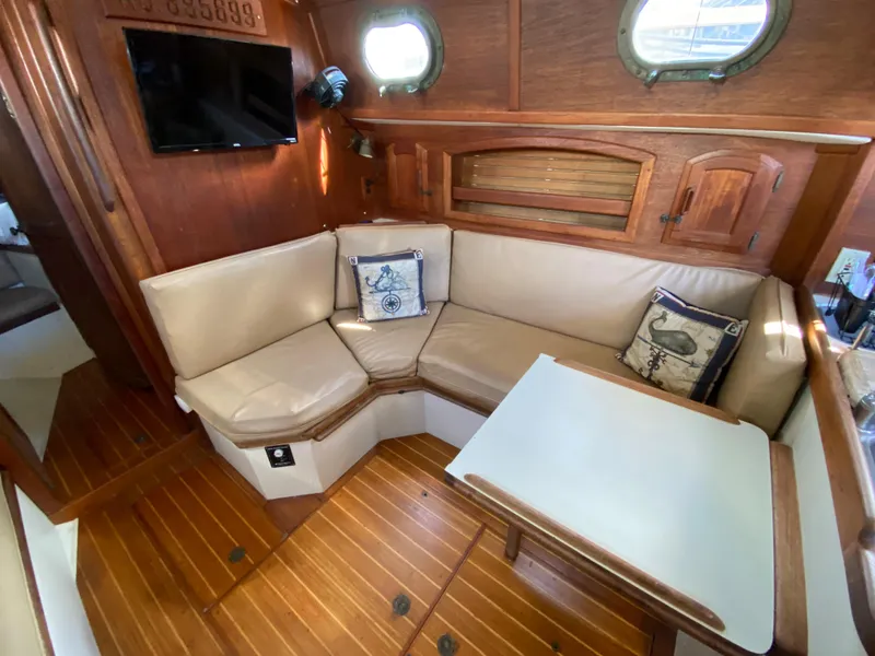Slide: The Image of Interior of 1986 Pacific Seacraft Crealock 37 sailboat with cozy seating and wooden accents. - 8