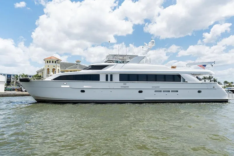 Slide: The Image of Hatteras 100 Motor Yacht 2004 on water, with clear sky and waterfront buildings. - 1