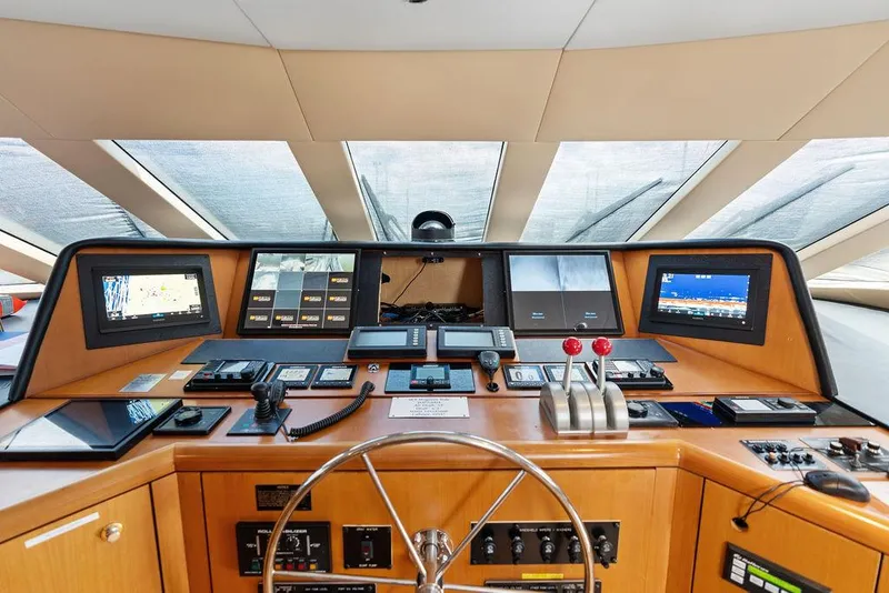 Slide: The Image of Control panel of a 2004 Hatteras 100 Motor Yacht with navigation screens and controls. - 19