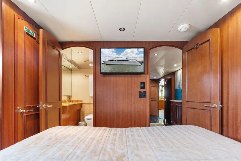 Slide: The Image of Luxurious 2004 Hatteras 100 Motor Yacht bedroom with ensuite bathroom and wooden interior. - 44