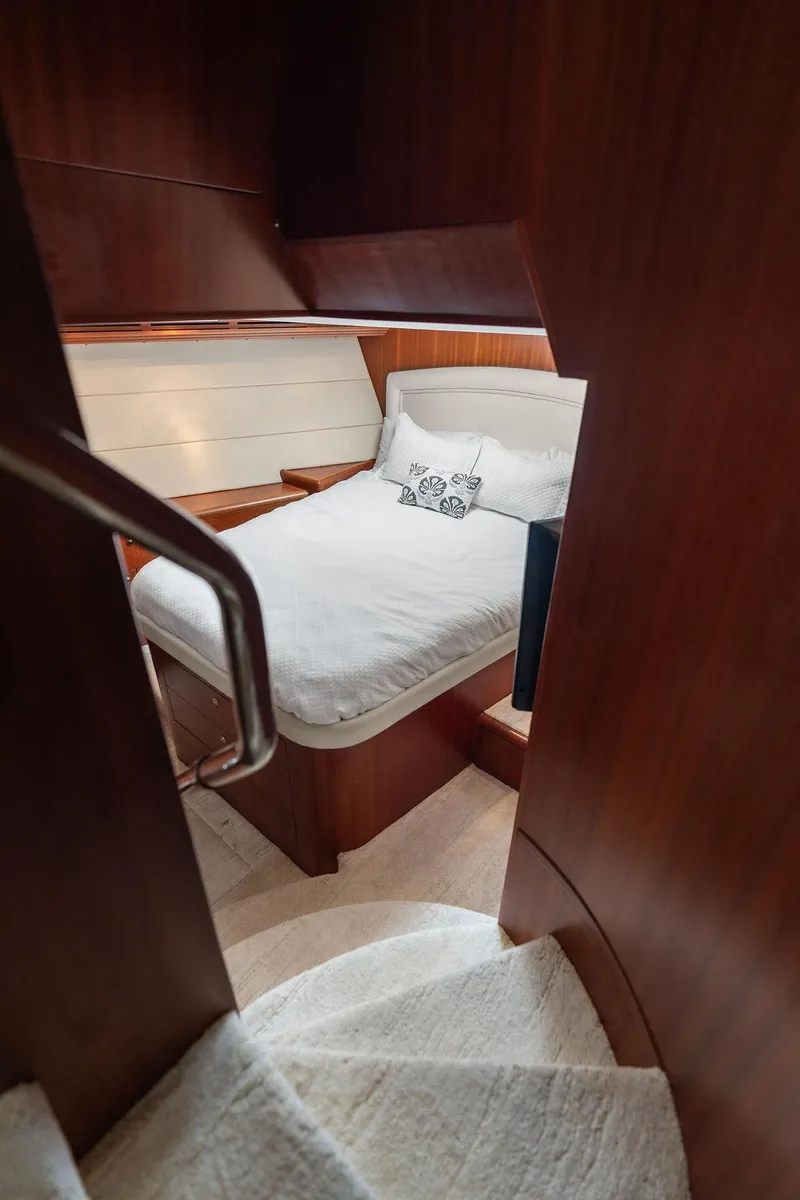 Slide: The Image of Cozy bedroom in 2004 Hatteras 100 Motor Yacht with wooden interior and plush bedding. - 47