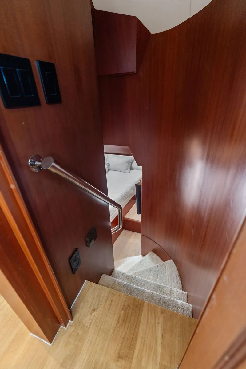Slide: The Image of Staircase inside 2004 Hatteras 100 Motor Yacht with wooden paneling and carpeted steps. - 48