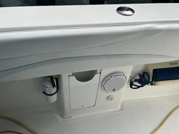 Slide: The Image of 2008 Spectre 34 boat interior with speaker, storage, and coiled hose. - 33
