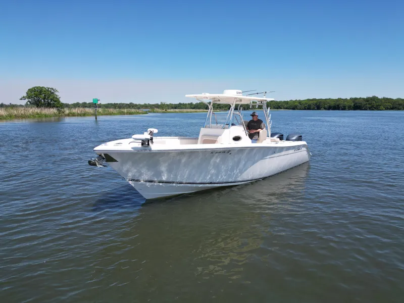 Slide: The Image of 2013 Cobia 296 Center Console boat on calm water under clear blue sky. - 1