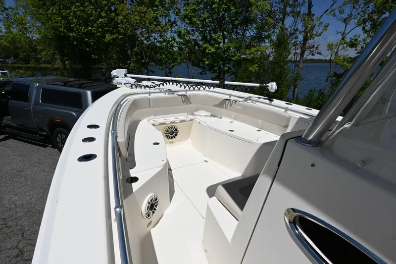 Slide: The Image of 2013 Cobia 296 Center Console boat with spacious seating, docked near a lake. - 10
