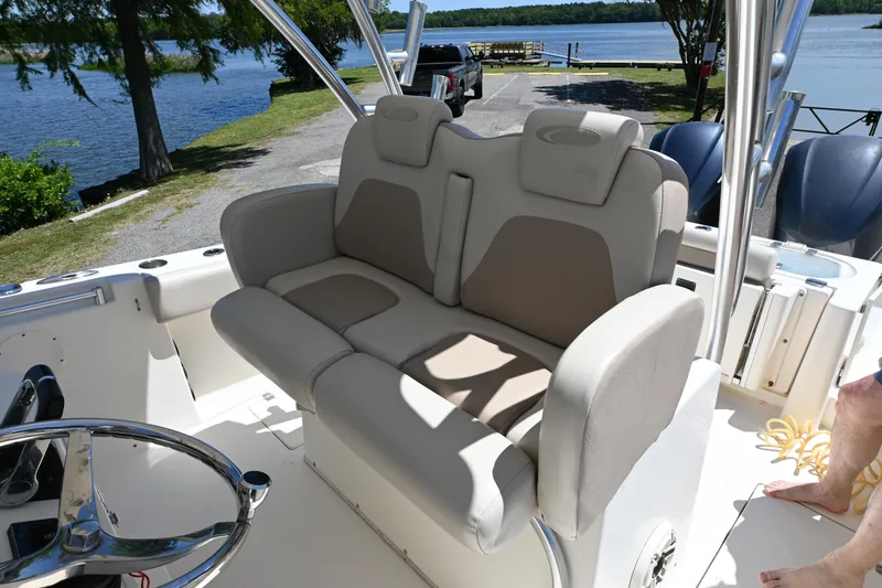 Slide: The Image of 2013 Cobia 296 Center Console boat with comfortable seating by a scenic lake. - 11