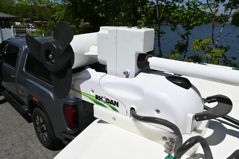 Slide: The Image of Trolling motor on a 2013 Cobia 296 Center Console near a lake. - 12