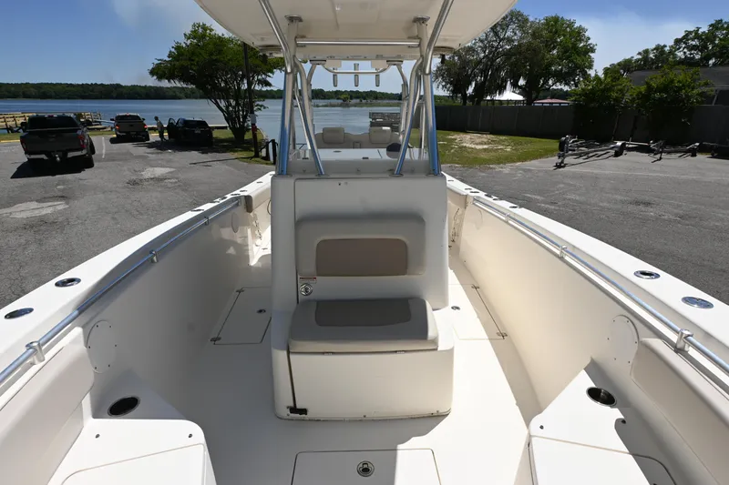 Slide: The Image of 2013 Cobia 296 Center Console boat at a lakeside dock, featuring spacious seating. - 13
