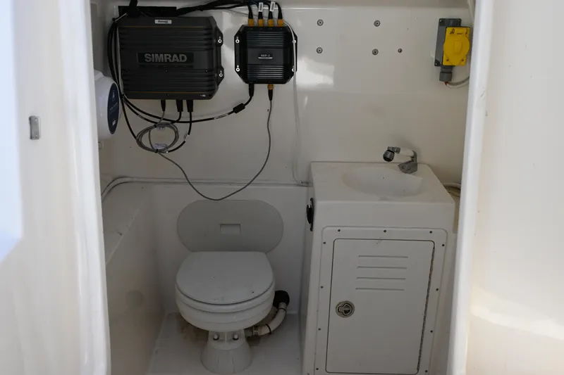 Slide: The Image of Interior of 2013 Cobia 296 Center Console boat with toilet and sink. - 14