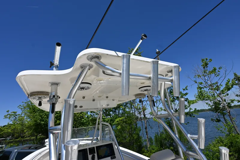 Slide: The Image of 2013 Cobia 296 Center Console boat with rod holders, blue sky background. - 17