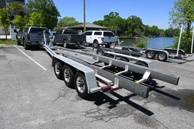 Slide: The Image of 2013 Cobia 296 Center Console trailer parked near a lake with trucks. - 20