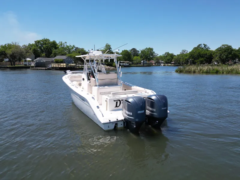 Slide: The Image of 2013 Cobia 296 Center Console boat on calm water, clear sky, distant shoreline. - 5