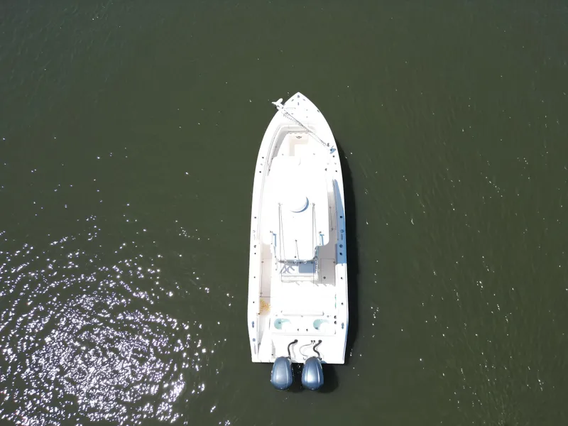 Slide: The Image of 2013 Cobia 296 Center Console boat with dual Yamaha engines on a calm river. - 6