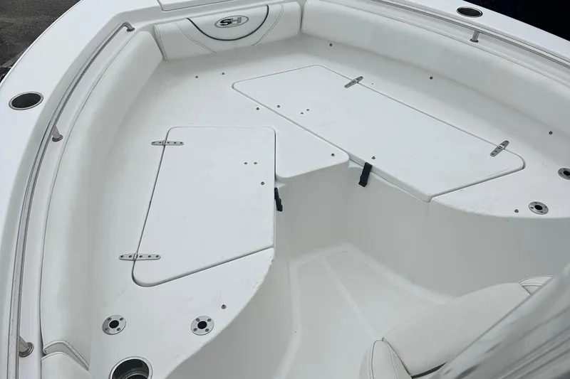 Slide: The Image of 2017 Sea Hunt Ultra 234 boat interior with white seating and storage compartments. - 12