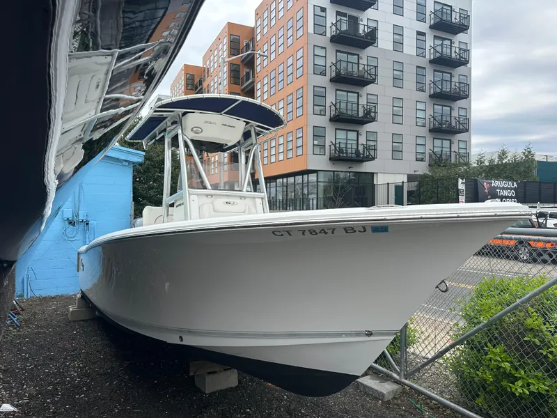 Slide: The Image of 2017 Sea Hunt Ultra 234 boat parked near modern apartment buildings. - 2