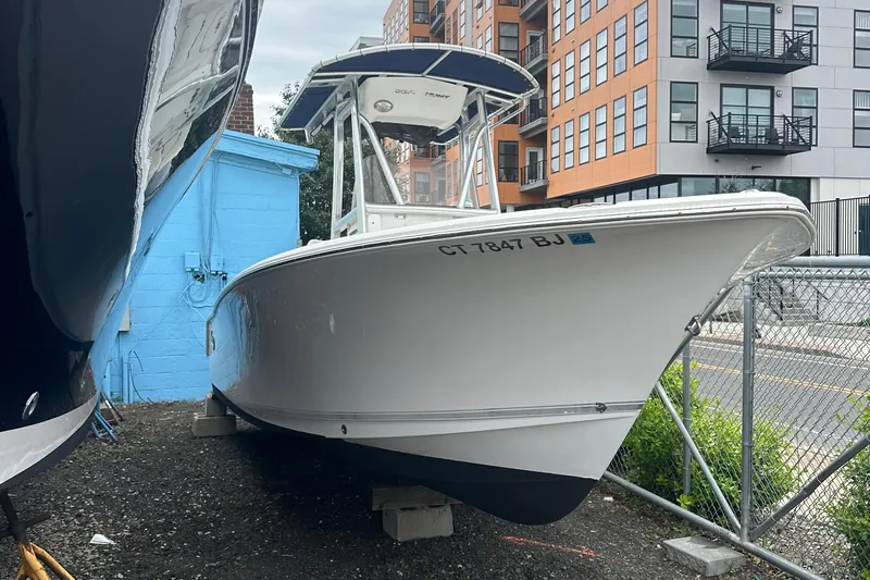 Slide: The Image of 2017 Sea Hunt Ultra 234 boat docked near urban buildings. - 3