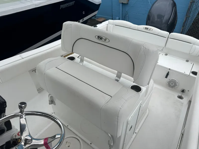 Slide: The Image of 2017 Sea Hunt Ultra 234 boat interior with white seating and steering wheel. - 9