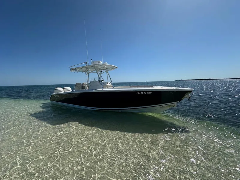 The Image of 2009 Jupiter 29 FS CC boat anchored on clear, shallow water under a bright blue sky. - 0