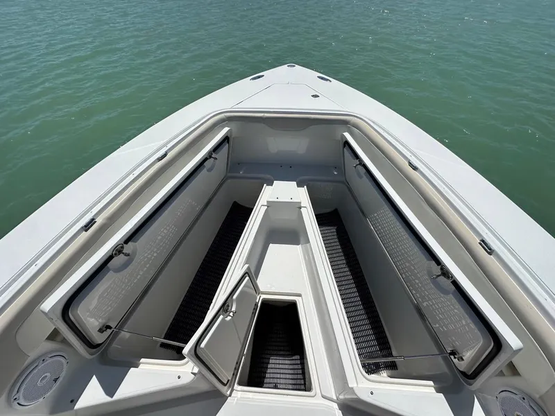 Slide: The Image of Bow storage compartments on a 2009 Jupiter 29 FS CC boat, open on calm water. - 12