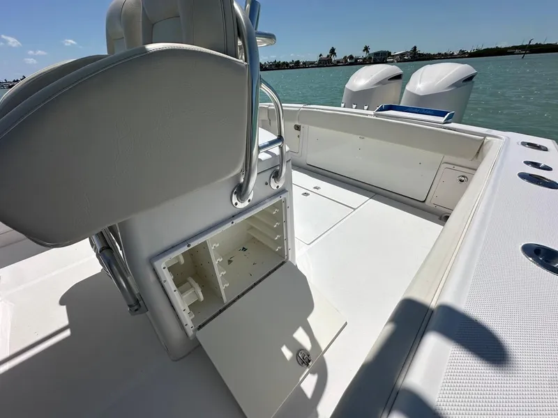 Slide: The Image of 2009 Jupiter 29 FS CC boat interior with open storage compartment, dual engines, and ocean view. - 26
