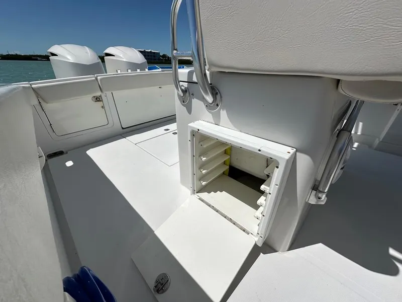 Slide: The Image of 2009 Jupiter 29 FS CC boat interior with open storage compartment and dual engines. - 28