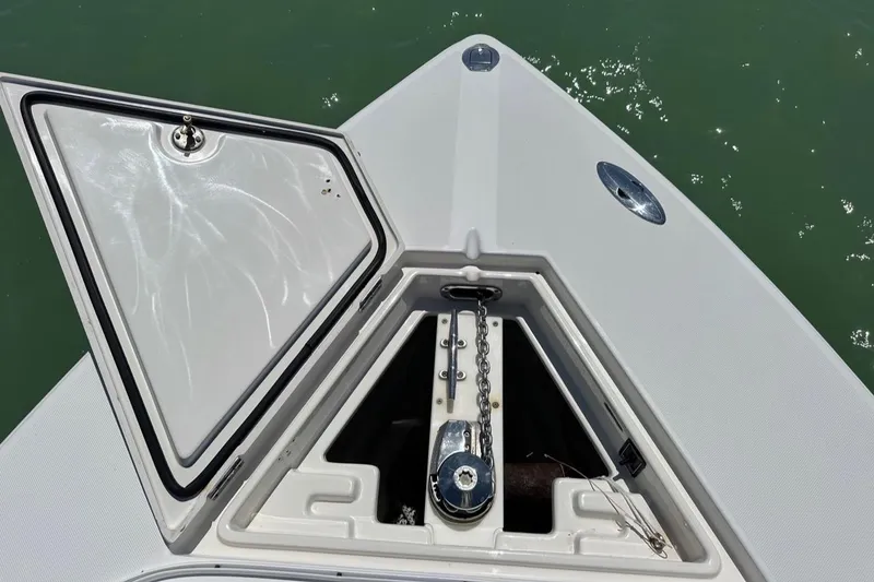 Slide: The Image of 2009 Jupiter 29 FS CC boat anchor compartment with open hatch, showing chain and winch. - 8
