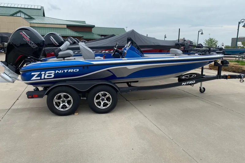 Slide: The Image of 2024 Nitro Z18 Pro boat, blue and white, on a trailer in an outdoor setting. - 1