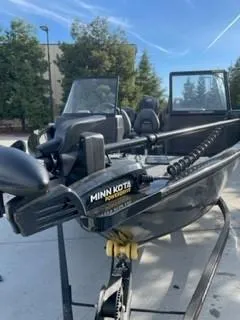 Slide: The Image of 2025 Tracker Pro Guide V-175 WT boat with Minn Kota motor, parked outdoors. - 4