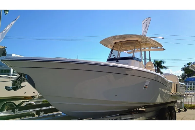 Slide: The Image of 2025 Grady-White 281 Coastal Explorer boat on trailer under clear blue sky. - 1