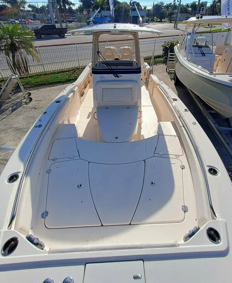 Slide: The Image of 2025 Grady-White 281 Coastal Explorer boat, spacious deck, sleek design, docked outdoors. - 7