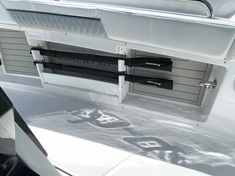 Slide: The Image of 2025 Blackfin 302CC boat interior with rod holders and sleek design. - 18