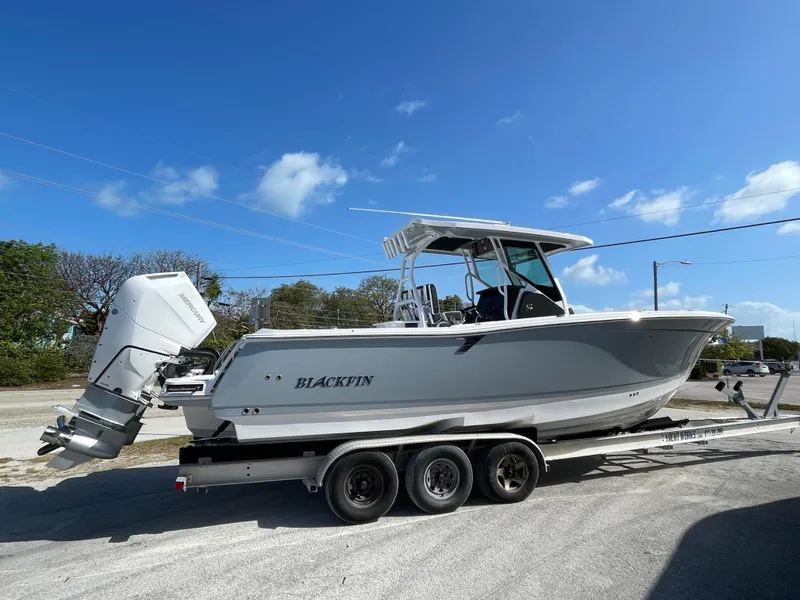 Slide: The Image of 2025 Blackfin 302CC boat on trailer under clear blue sky. - 2