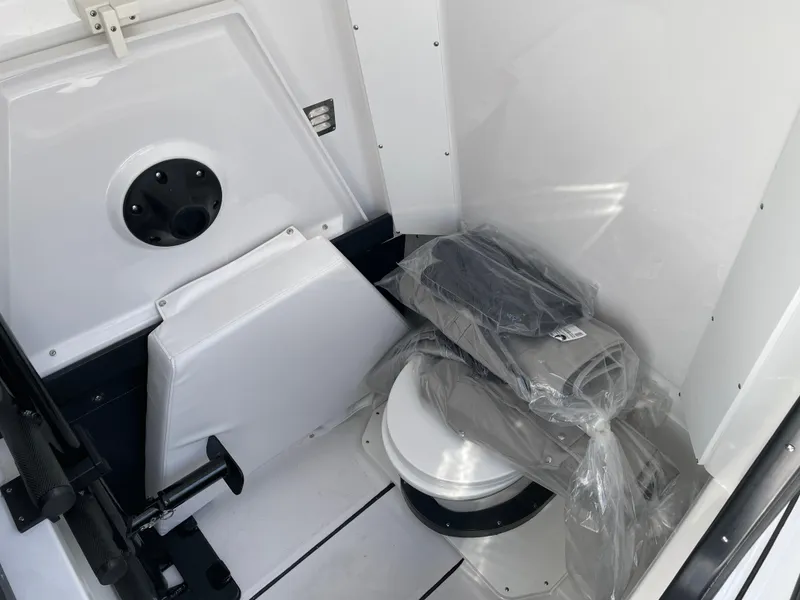 Slide: The Image of 2025 Blackfin 302CC boat interior with a compact marine toilet and storage area. - 38