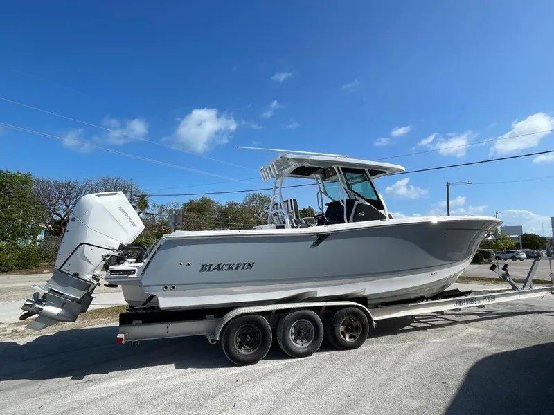 Slide: The Image of 2025 Blackfin 302CC boat on trailer under clear blue sky. - 4