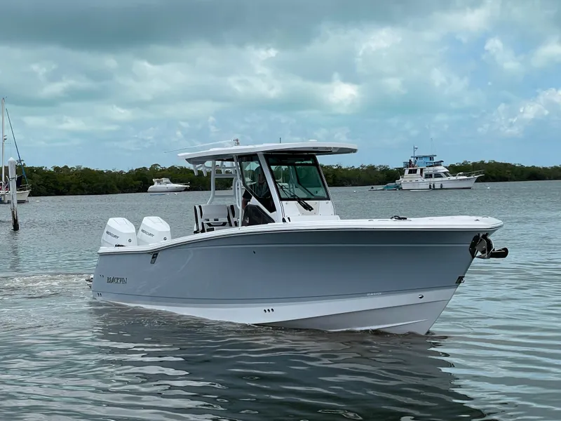 Slide: The Image of 2025 Blackfin 302CC boat cruising on calm waters under a cloudy sky. - 48