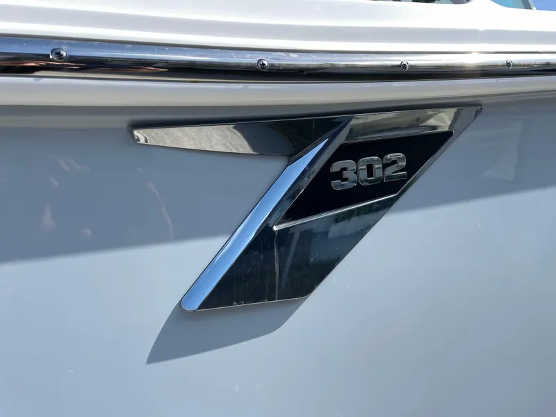 Slide: The Image of 2025 Blackfin 302CC boat emblem on sleek white surface. - 6