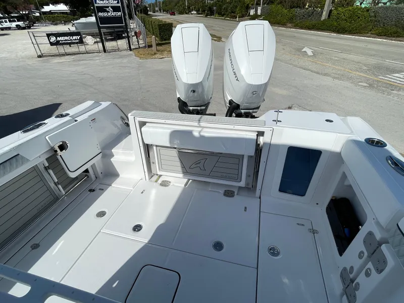 Slide: The Image of 2025 Blackfin 302CC boat deck with dual outboard motors, spacious layout, and storage compartments. - 8