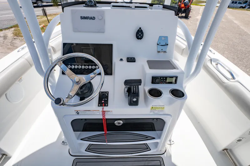 Slide: The Image of 2019 Sea Pro 219 DLX boat console with steering wheel, controls, and Simrad display. - 16