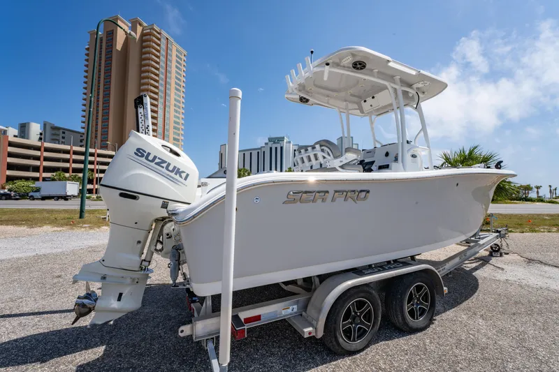 Slide: The Image of 2019 Sea Pro 219 DLX boat on trailer with Suzuki outboard, urban backdrop. - 3