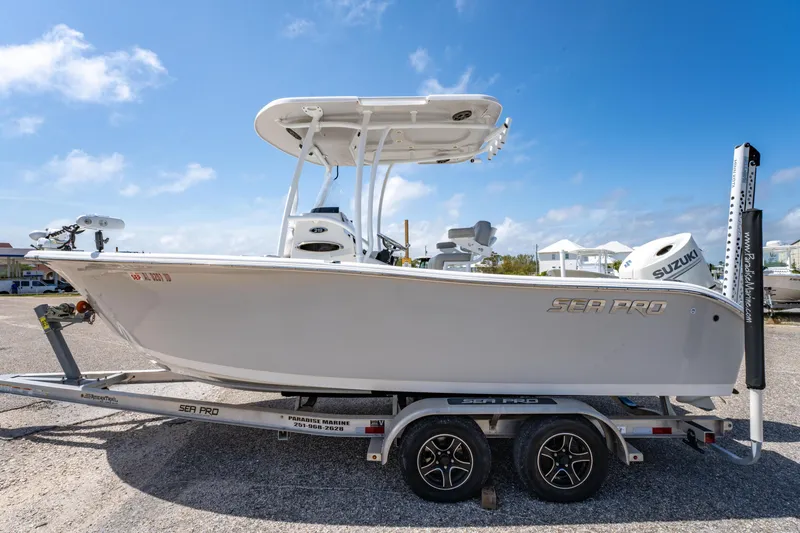 Slide: The Image of 2019 Sea Pro 219 DLX boat on trailer under clear blue sky. - 6