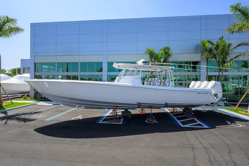 The Image of 2025 Contender 44ST boat on display outside modern building with palm trees. - 0