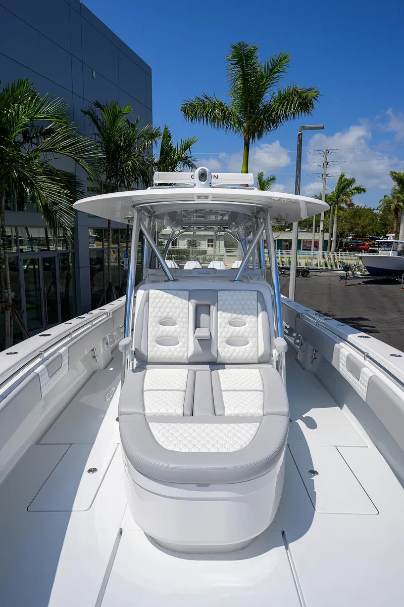 Slide: The Image of 2025 Contender 44ST boat with sleek design, white seating, and modern features under a clear blue sky. - 11